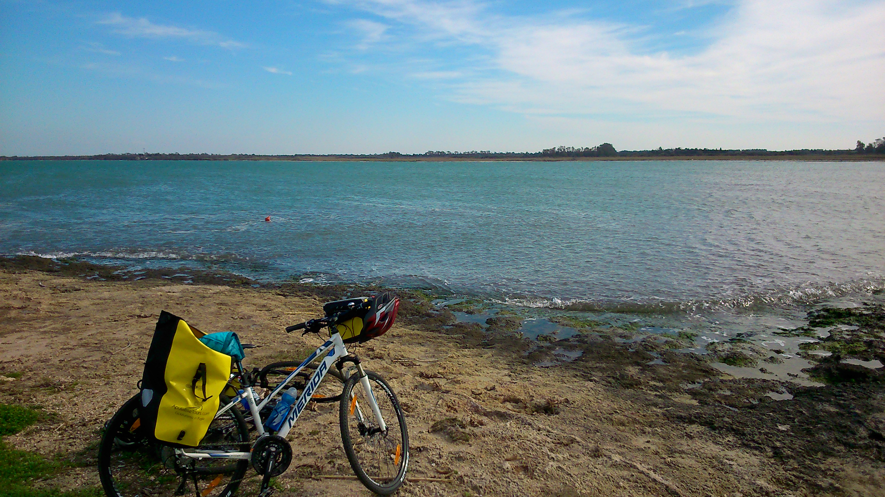 A hybrid bike with panniers on an Apulian beach