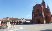 Cycle past the brick red gothic church in Pollenzo, Piedmont